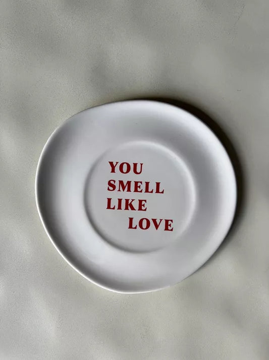 Assiette Tu sens l'amour blanche cassée avec texte rouge « You smell like love », finition brillante, idéale pour dessert ou décoration murale.