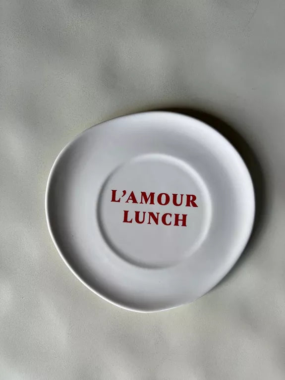 Assiette à dessert Déjeuner L'amour lunch en céramique blanc cassé avec texte rouge au centre, idéale pour une table romantique et moderne.