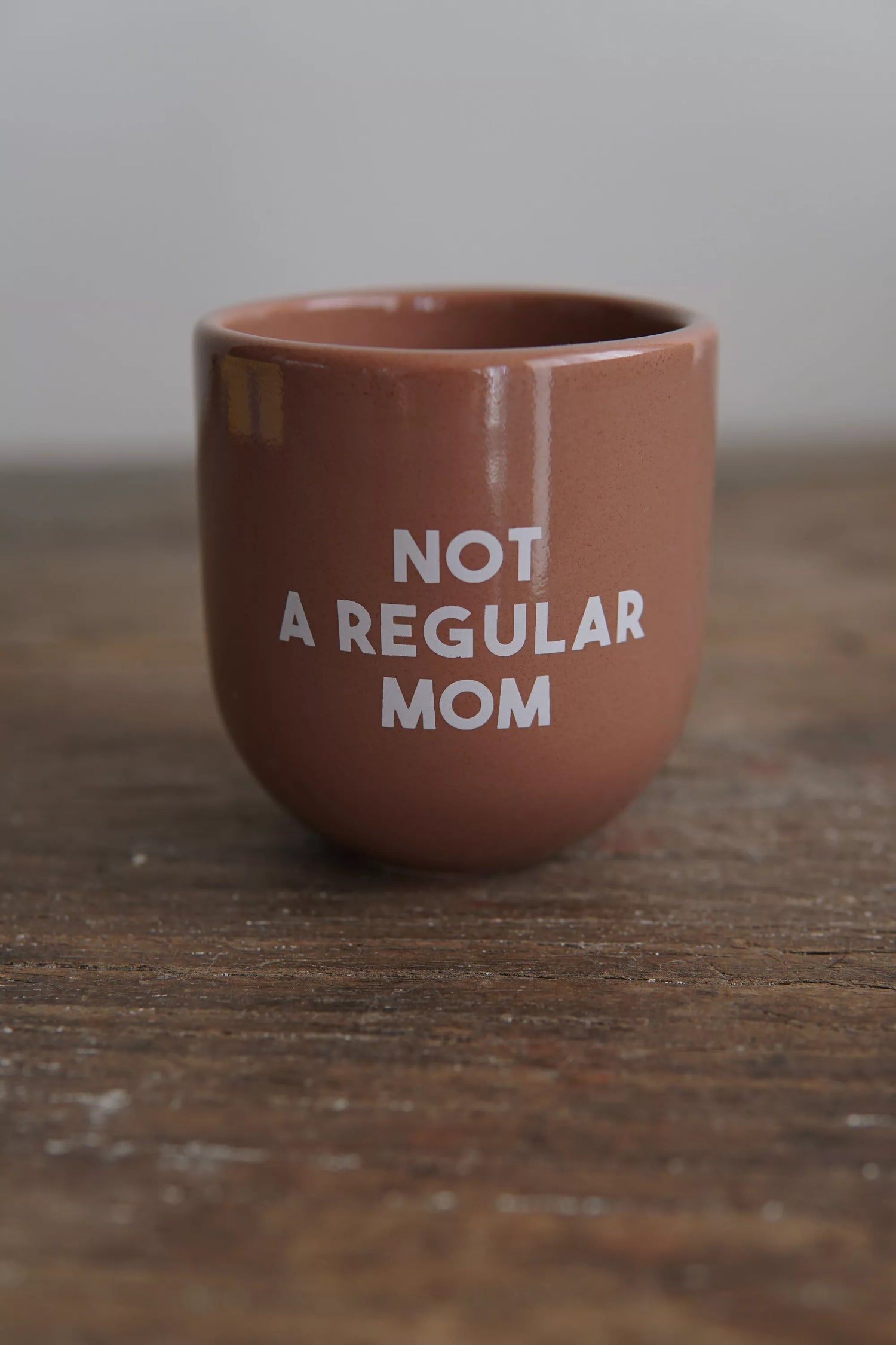 Mug en céramique marron avec inscription blanche 'Not a Regular Mom', parfait pour les mamans originales. Idéal pour café ou thé au quotidien.